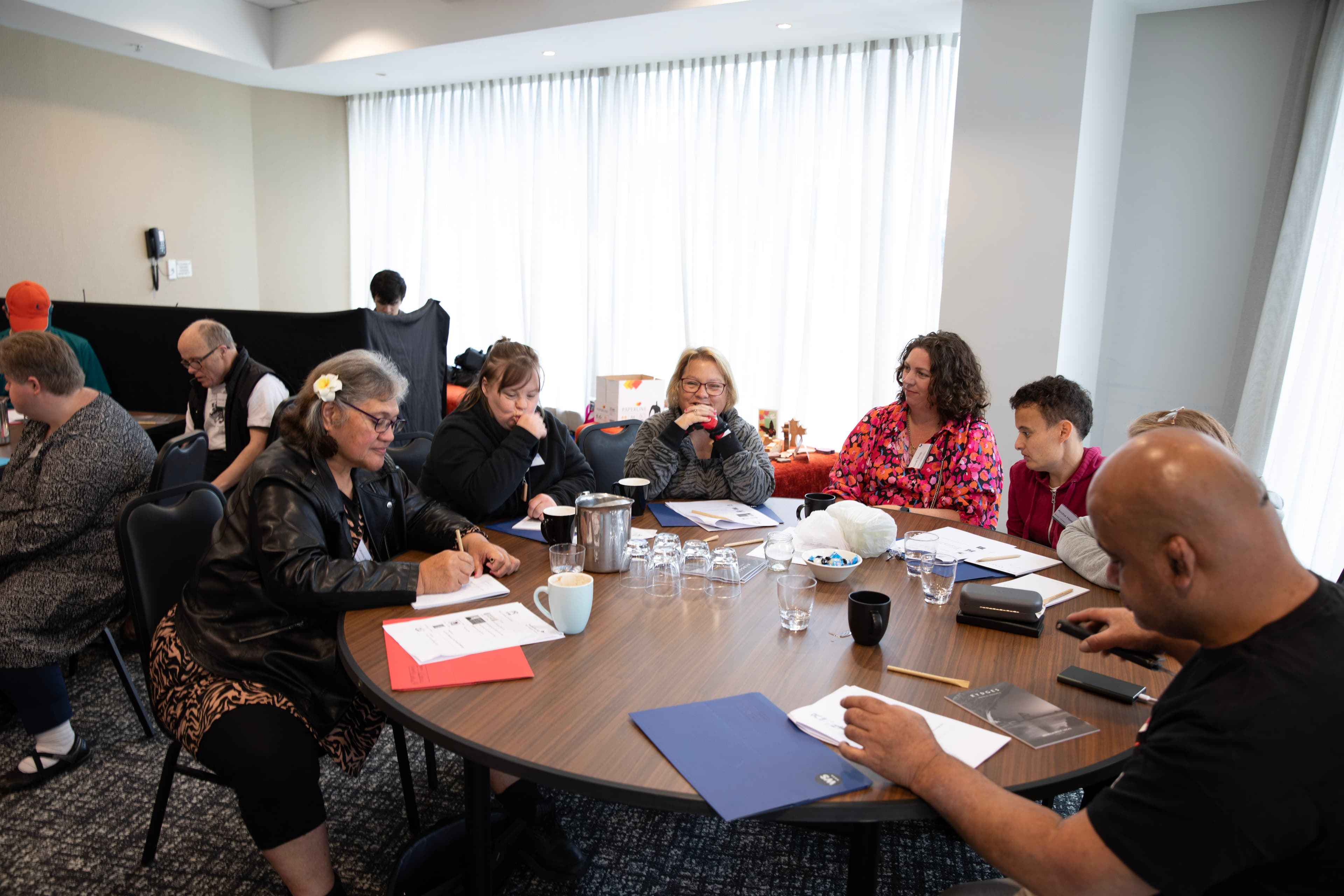 A group photo of people at a table during a leadership forum.